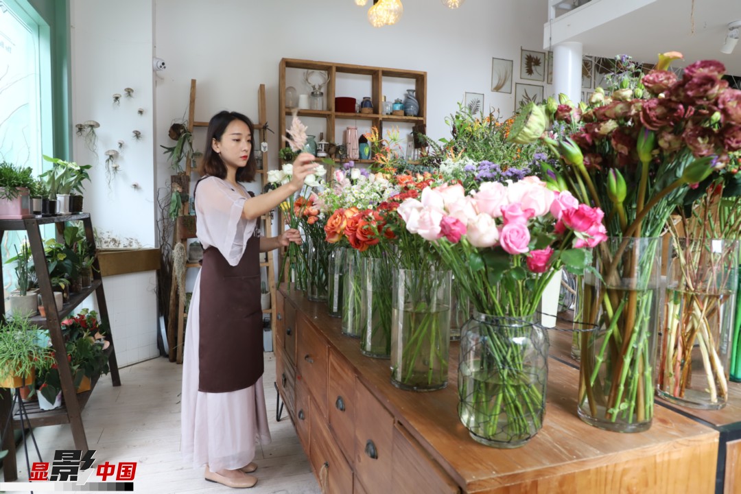 王黎媛是一名河南姑娘，在昆明念完大學(xué)后，就再也舍不下春城的藍(lán)天陽(yáng)光、青山碧水，更舍不下這里的四時(shí)繁花，于是就干脆留了下來(lái)，成了一名媒體人。2017年的時(shí)候又毅然辭去工作，創(chuàng)業(yè)開(kāi)起了花店，成了都市里的一名“花房姑娘”。圖為王黎媛在自己的花店中整理鮮花。新華網(wǎng) 周亞平/攝 念新洪/文